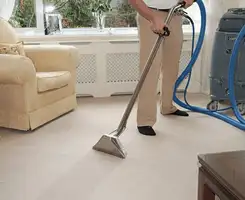 Carpet cleaning professional removing dirt and stains with a hot-water extraction tool in a home, Aurora, IL.