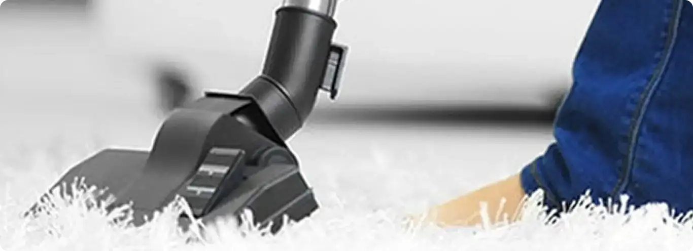 Close-up of a professional vacuuming a white carpet in Batavia.